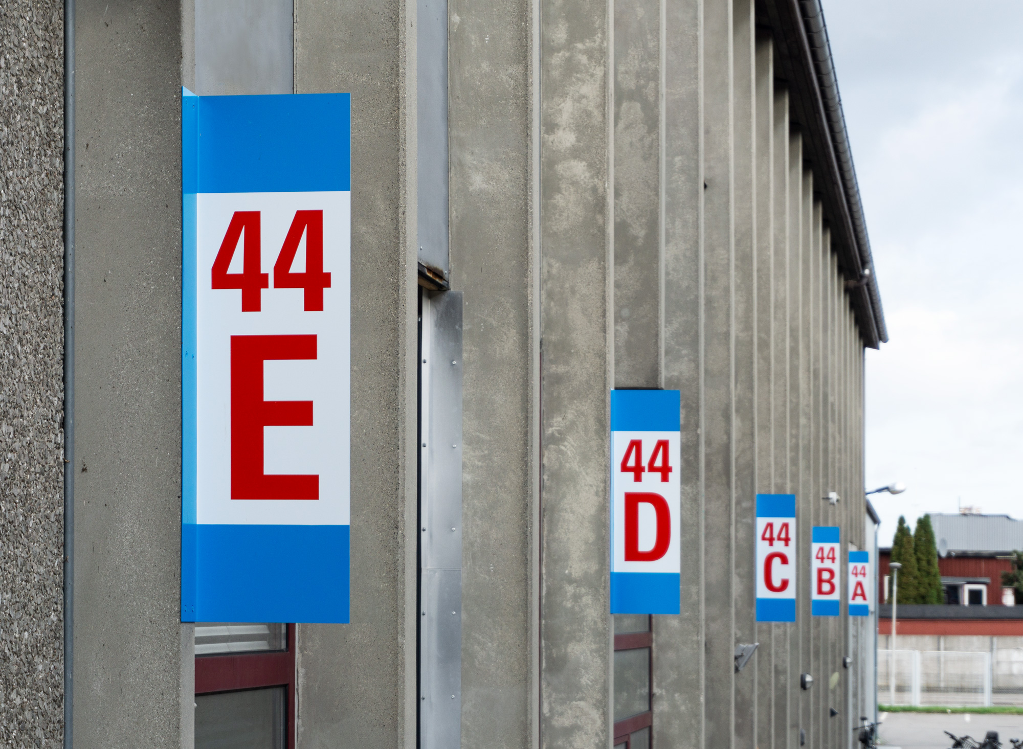 Overhang signs on concrete facade.
