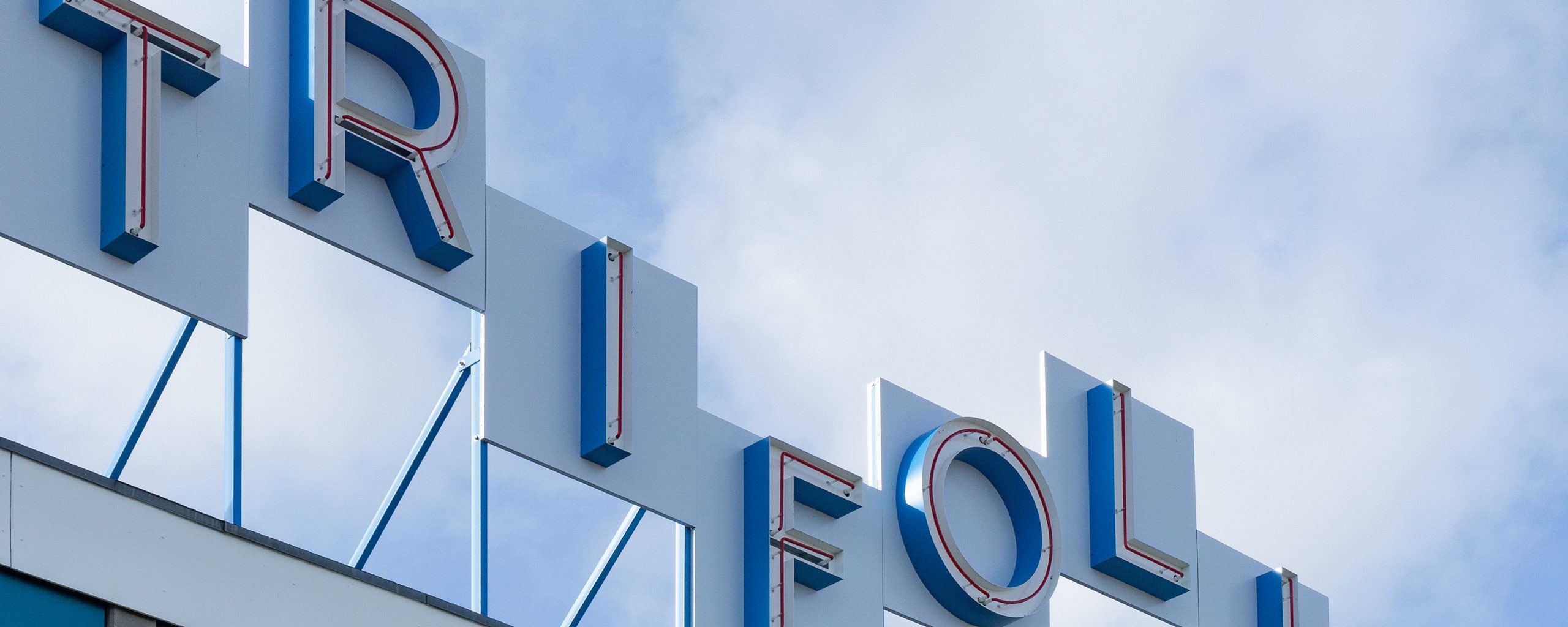 Trifolium neon sign on building roof.