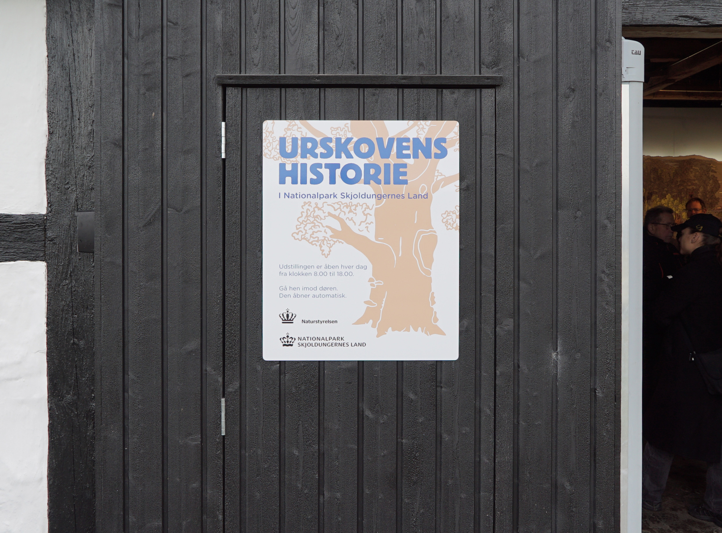 Welcome sign with exhibition name on exterior door.